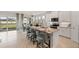 Bright, open kitchen with white cabinets, marble countertops, and stainless steel appliances, overlooking dining area at 15968 Crofton Springs Way, Port Charlotte, FL 33953