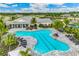 Aerial view of a modern community pool featuring lap lanes, lounge seating and landscaping at 15968 Crofton Springs Way, Port Charlotte, FL 33953