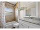 Bathroom featuring granite countertop, decorative mirror and tiled shower with seahorse curtain at 16094 Ortega Dr, Punta Gorda, FL 33955