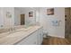 Bathroom featuring dual sinks, marble countertops, decorative mirror and tiled shower at 16094 Ortega Dr, Punta Gorda, FL 33955
