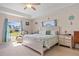 Comfortable bedroom with tray ceiling, nautical decor, and large windows providing ample natural light at 16094 Ortega Dr, Punta Gorda, FL 33955