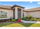 A close exterior view shows the welcoming home entrance and lush, colorful garden bed at 16094 Ortega Dr, Punta Gorda, FL 33955