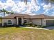 A home's exterior view showcases a well-manicured lawn and complementary landscaping at 16094 Ortega Dr, Punta Gorda, FL 33955