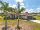 Inviting single-story home with an attached two-car garage, mature palms, and attractive landscaping at 16094 Ortega Dr, Punta Gorda, FL 33955