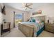 Spacious bedroom with a large bed, a ceiling fan, and a window overlooking the neighborhood at 16094 Ortega Dr, Punta Gorda, FL 33955