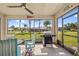 The screened patio includes a ceiling fan and a grill with views of the spacious back yard at 16094 Ortega Dr, Punta Gorda, FL 33955