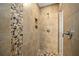 Walk-in shower featuring decorative stone accents, neutral tile and a built-in shower caddy at 16094 Ortega Dr, Punta Gorda, FL 33955