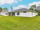 The back of the home showcases the neutral stucco and screened patio at 17130 Elder St, Port Charlotte, FL 33954