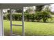 A row of green plants line the grassy backyard as seen from the patio at 17130 Elder St, Port Charlotte, FL 33954