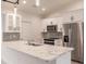 Modern kitchen with stainless steel appliances, stone backsplash, and large island at 17130 Elder St, Port Charlotte, FL 33954