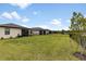Spacious backyard featuring a green lawn, black metal fence, and beautiful views of adjacent houses at 1734 Saddlewood Cir, Port Charlotte, FL 33953