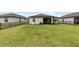 Expansive green backyard featuring a screened-in patio and secure black metal fencing at 1734 Saddlewood Cir, Port Charlotte, FL 33953