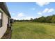 Expansive backyard featuring a well-manicured lawn, black metal fence, and tranquil views of the surrounding nature at 1734 Saddlewood Cir, Port Charlotte, FL 33953