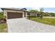 Long driveway leads to a well-manicured home and garage with lush landscaping at 1734 Saddlewood Cir, Port Charlotte, FL 33953