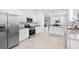 Well-lit white kitchen with stainless appliances and open floor plan at 1734 Saddlewood Cir, Port Charlotte, FL 33953