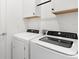 Modern laundry room featuring a front-load washer and dryer with white cabinetry and ample storage space at 1734 Saddlewood Cir, Port Charlotte, FL 33953