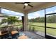 Screened patio with comfortable seating, scenic backyard views, and a ceiling fan for added comfort at 1734 Saddlewood Cir, Port Charlotte, FL 33953