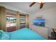 This bedroom overlooks the pool and canal and contains a tv, dresser and a ceiling fan at 190 Casa Ln, Punta Gorda, FL 33950