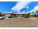 Charming coral home with a white metal roof, lush landscaping, and a welcoming front entrance at 190 Casa Ln, Punta Gorda, FL 33950