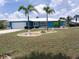 Charming single-story home with a bright blue exterior, white trim, and meticulously manicured landscaping at 190 Casa Ln, Punta Gorda, FL 33950