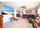 Bright living room featuring a plush leather sectional, coastal artwork, ceiling fan, and a beach scene displayed on the TV at 190 Casa Ln, Punta Gorda, FL 33950