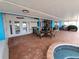 Covered patio featuring an outdoor seating area, fitness equipment, and access to a built-in hot tub at 190 Casa Ln, Punta Gorda, FL 33950