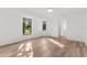 A bright bedroom with wood floors, two windows, and a door to a bathroom at 19723 Midway Blvd, Port Charlotte, FL 33948