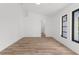 A bedroom with light wood flooring, white walls, and a window with black trim at 19723 Midway Blvd, Port Charlotte, FL 33948