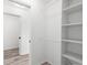 A closet with white walls, shelving, hanging racks, and wood-look floors at 19723 Midway Blvd, Port Charlotte, FL 33948