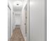 Hallway with tan tile, white walls, and doorways leading to other rooms at 19723 Midway Blvd, Port Charlotte, FL 33948