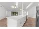 Open kitchen features a center island with a marble countertop and modern appliances at 19723 Midway Blvd, Port Charlotte, FL 33948