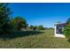 Expansive green backyard with a view of a serene water feature, seen from the corner of the home at 2271 Alton Rd, Port Charlotte, FL 33952