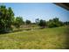 Lush backyard featuring a healthy lawn, mature trees, and a tranquil pond, creating a private oasis at 2271 Alton Rd, Port Charlotte, FL 33952