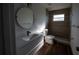 Modern bathroom with tiled walk-in shower, hardwood floors, and round mirror at 2271 Alton Rd, Port Charlotte, FL 33952