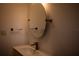 A clean bathroom features a modern sink, round mirror, and minimalist design at 2271 Alton Rd, Port Charlotte, FL 33952