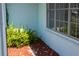 The home's exterior shows a corner of the structure, window and some greenery in the decorative bark at 2271 Alton Rd, Port Charlotte, FL 33952