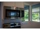 Close-up of a sleek microwave and electric cooktop in a renovated kitchen with outdoor views at 2271 Alton Rd, Port Charlotte, FL 33952