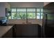 Modern kitchen featuring gray cabinetry, stainless steel appliances, and bright windows at 2271 Alton Rd, Port Charlotte, FL 33952