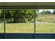 Tranquil backyard view from the screened lanai, showcasing lush greenery and a peaceful pond at 2271 Alton Rd, Port Charlotte, FL 33952