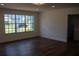 Bright living room with a large window showcasing neighborhood views and modern hardwood floors at 2271 Alton Rd, Port Charlotte, FL 33952