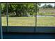 Screened-in patio view of the green lawn extending to a scenic pond with lush foliage and a visiting heron at 2271 Alton Rd, Port Charlotte, FL 33952