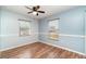 Bright bedroom featuring wood-look flooring, two windows and a ceiling fan with light fixture at 2420 Linton Ln, Port Charlotte, FL 33952