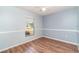 Bedroom featuring hardwood-look floors, a window, and blue walls with white trim at 2420 Linton Ln, Port Charlotte, FL 33952