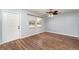 Bright living room with wood-look floors, ceiling fan, and a white front door with sidelight windows at 2420 Linton Ln, Port Charlotte, FL 33952