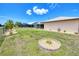 A well-maintained backyard featuring green grass, a charming stone-lined plant bed, and neighboring screened-in pools at 25379 Paladin Ln, Punta Gorda, FL 33983
