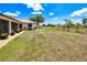 Expansive backyard featuring manicured landscaping, a well-maintained lawn, and outdoor grilling area at 25379 Paladin Ln, Punta Gorda, FL 33983