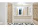 Bright bathroom with double sink vanity, large mirror and glass door to shower at 25379 Paladin Ln, Punta Gorda, FL 33983