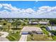 An appealing exterior view of a single-story home with a well-manicured lawn, circular driveway, and mature trees at 25379 Paladin Ln, Punta Gorda, FL 33983