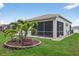Well-manicured backyard features a screened lanai and lush landscaping at 26111 Feathersound Dr, Punta Gorda, FL 33955