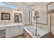 Bathroom showcasing a soaking tub with tile surround and double vanity with modern fixtures at 26111 Feathersound Dr, Punta Gorda, FL 33955